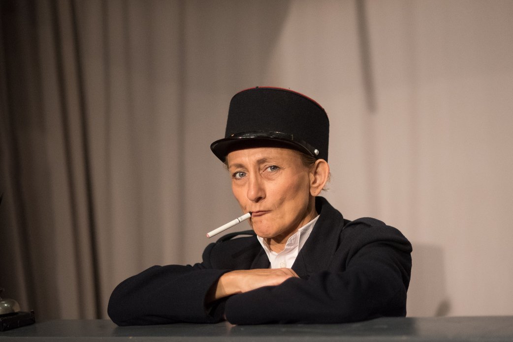 Die Busfahrerin. Christine Janner als Busfahrerin mit lässigem Gesichtsausdruck und Zigarette im Mundwinkel.