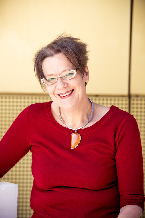 Barbara Bücking, Besucher·innenservice im Theater Pfütze in Nürnberg vor goldener Hausfassade des Theaters
