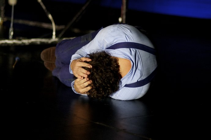 Das Kind der Seehundfrau. Foto aus dem Theaterstück: Schauspieler Andreas Wagner kauert verzweifelt auf dem Boden.
