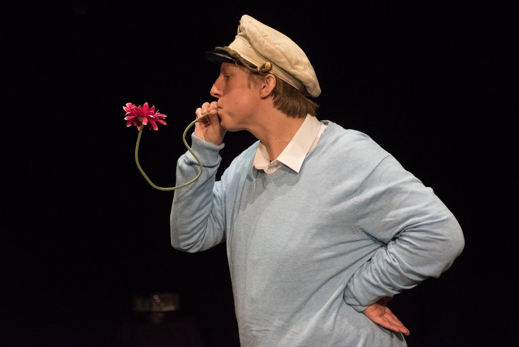 Die Busfahrerin. Darsteller Thomas Bosch pustet in einen Blumenstiel.