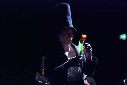Ente, Tod und Tulpe. Christof Lappler in der Rolle Tod hält eine Tulpe in der Hand.